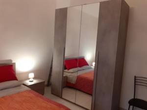 einen Spiegel in einem Zimmer mit 2 Betten und einem roten Bett in der Unterkunft la casa di Luca in Asti
