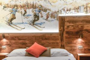 a bedroom with a painting of skiers on the wall at Serendipity Hotel in Sauze dʼOulx