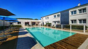 a swimming pool in front of a building at Citotel Hôtel Le Capricorne in Marmande