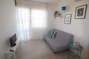 sala de estar con sofá y TV en Residence Schubert, en Lignano Sabbiadoro