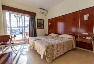 1 dormitorio con 1 cama grande y balcón en Nch Hotel Torremolinos, en Torremolinos