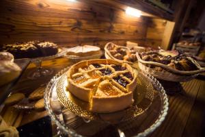 uma tarte num prato de vidro numa mesa com outras sobremesas em Serendipity Hotel em Sauze dʼOulx