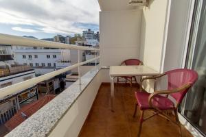 balkon z 2 krzesłami i stołem w budynku w obiekcie Nch Hotel Torremolinos w mieście Torremolinos