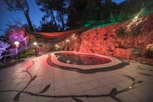 a stone wall with a hot tub at night at Palacete in Barcelona