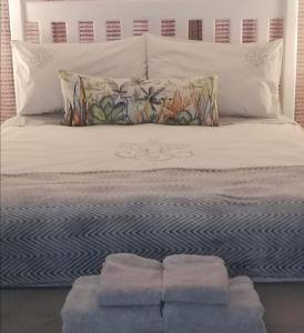 a bed with two pillows and two towels on it at Garsfontein Bed and Breakfast in Pretoria