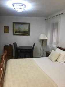 a bedroom with a bed and a desk and a table at Chambre du couvent in Narbonne