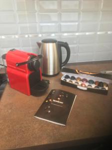 a counter with a coffee pot and a box of cupcakes at charmant studio Pont-Audemer in Pont-Audemer