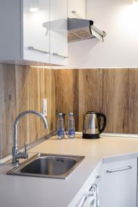 a kitchen counter with a sink and a kettle at Pokoje Gold Centrum in Koszalin