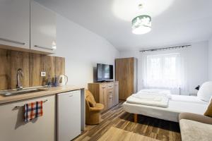 a kitchen with a sink and a living room at Pokoje Gold Centrum in Koszalin