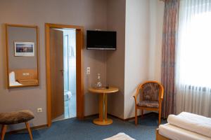 a hotel room with a table and a television on the wall at Hotel Waldfrieden in Emmelshausen