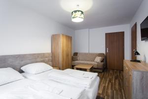 a bedroom with two beds and a couch at Pokoje Gold Centrum in Koszalin