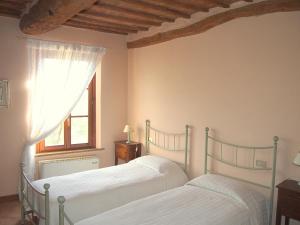 two beds in a bedroom with a window at Nell'Antica Torre di Fronte a Siena in Siena