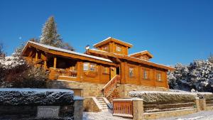 a large wooden house with snow on it at Le Renne Blanc Pyrénées de France in Font-Romeu