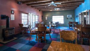 een eetkamer met tafels en stoelen en een houtkachel bij Abiquiu Inn in Abiquiu