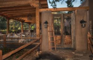 a wooden porch with a ladder and a table at Abiquiu Inn in Abiquiu
