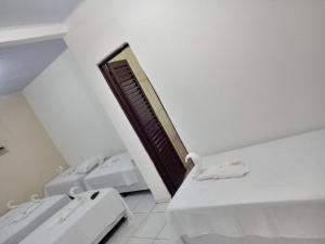 a white room with two beds and a window at Pousada Bela Vista de Mateiros in Mateiros