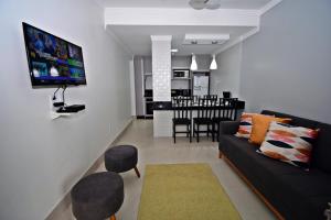 a living room with a couch and a dining room at Morada Pinheiro 160m da Praia in Bombinhas