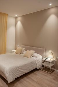 a bedroom with a large bed and a table at NICOLA'S APARTMENTS in Bari