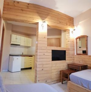 a room with a kitchen and a bedroom with a bed at Anemos Hotel in Polychrono