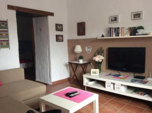 ein Wohnzimmer mit einem Sofa und einem TV in der Unterkunft Marisa Home in Orzola
