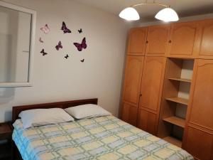 sypialnia z łóżkiem z motylami na ścianie w obiekcie Apartment Pula w Puli