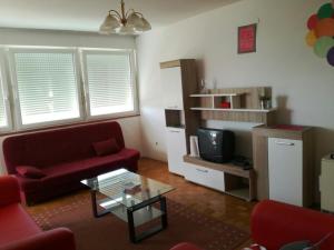 a living room with a red couch and a tv at Apartment Pula in Pula