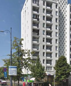 ワルシャワにあるPlac Bankowy Apartmentの市の通りに建つ高い白いアパートメントビル