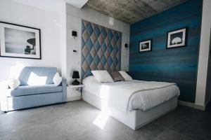 a bedroom with a bed and a chair at Valletta Collection - Ordinance Suites in Valletta