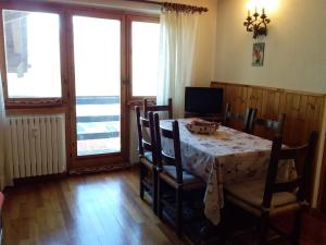 comedor con mesa, sillas y ventanas en Monte Cervino apartment AS14, en Breuil-Cervinia