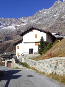 a white building on a hill with a mountain at Monte Cervino apartment AS14 in Breuil-Cervinia