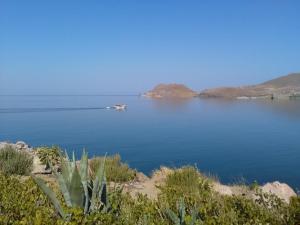 a boat in the middle of a large body of water at Enalion Apartments in Agios Ioannis Kaspaka