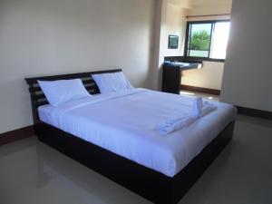 a bedroom with a large bed with white sheets at Jansupar Court in Chiang Rai