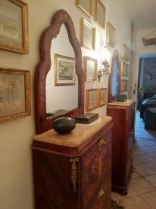タオルミーナにあるCasa Antica Savoiaの室内の木製ドレッサーの上に鏡