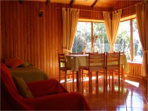 ein Esszimmer mit einem Tisch und einigen Stühlen in der Unterkunft Cabañas Vista al Lago in La Ensenada