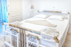 a white bed with white sheets and pillows on it at SeaScapeHome Serifos in Serifos Chora