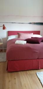a red bed with two pillows on top of it at Red flat by GrazRentals direct by University & free parking in Graz
