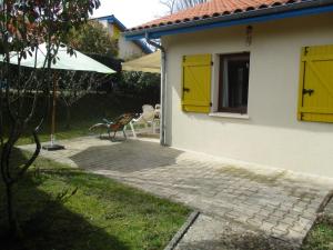 a house with yellow doors and a patio at Elartxo II in Saint-Julien-en-Born