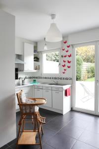 a kitchen with white cabinets and a wooden table at Cape Cod in Wimereux