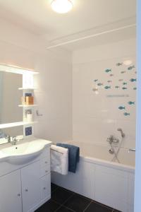 a white bathroom with a sink and a bath tub at Cape Cod in Wimereux