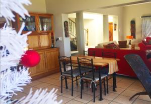 een woonkamer met een rode bank en een tafel en stoelen bij Fly Me To The Moon Guesthouse in Mosselbaai