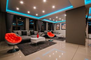 a living room with a couch and red chairs at Mountain Paradise & Wellness in Izvoare