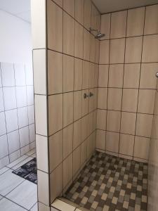 y baño con ducha y paredes de azulejos. en Plot 19, en Ghanzi
