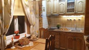 a kitchen with wooden cabinets and a table with a sink at Jurmala's Center Eco House in Jūrmala