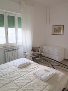 una camera da letto con un letto e una sedia di The Bright House ad Anzio