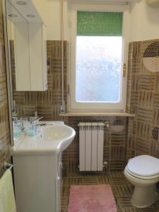 un bagno con lavandino, WC e finestra di The Bright House ad Anzio