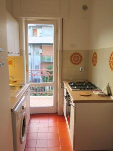 una cucina con porta aperta su un balcone di The Bright House ad Anzio Altre 16 foto