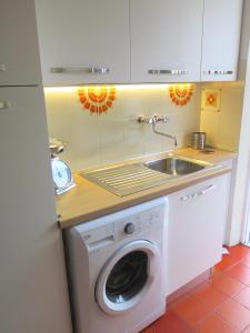 una cucina con lavatrice e lavandino di The Bright House ad Anzio
