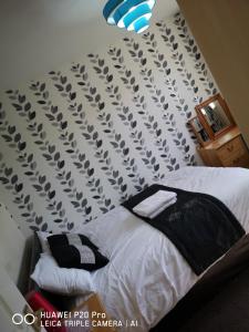 RICHFLO Holiday Rentals في مانشستر: غرفة نوم مع سرير مع نمط harlequin على الحائط