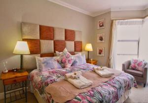 een slaapkamer met een groot bed en handdoeken bij Fly Me To The Moon Guesthouse in Mosselbaai
