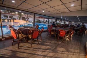 ein Restaurant mit Tischen und Stühlen sowie einem Pool in der Unterkunft Hotel Posada Tierra Blanca in Chihuahua